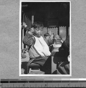 Child eating at Harwood Bible Training School, Fenyang, Shanxi, China, ca.1936-37