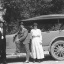Three people and an automobile