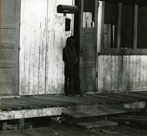 Child in front of World War II-era housing in Marin City, California, circa 1960 [photograph]