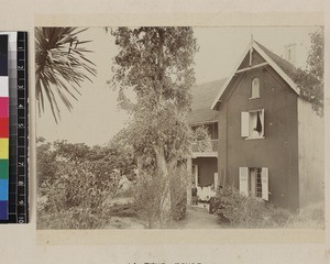 Missionary and household outside house, Madagascar, ca. 1890