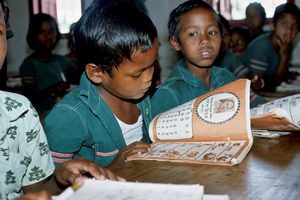 Diasserie for børn: "En dag på Saraswatipur Kostskole"- Nr. 16. Bidhan synes det er svært at lære at læse, men det er da sjovt at få sine egne bøger med flotte tegninger i. Det var også lidt svært at rejse hjemmefra, men nu går det bedre. Han har fået mange nye venner på skolen