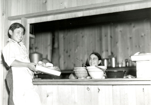 Young Mexican man and cook at a serving area