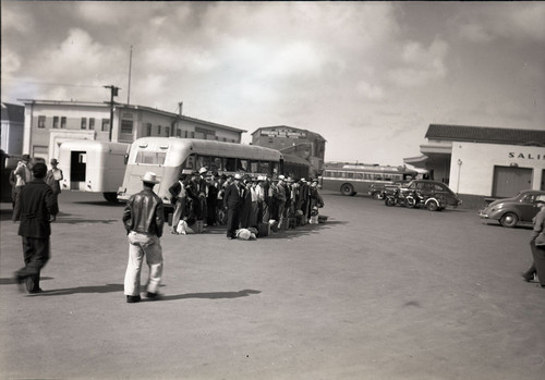 Last group of Mexican workers departing from train station by bus, Salinas, California