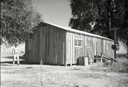 One labor camp building with a man standing nearby