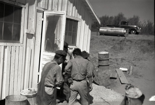 Four workers entering camp building