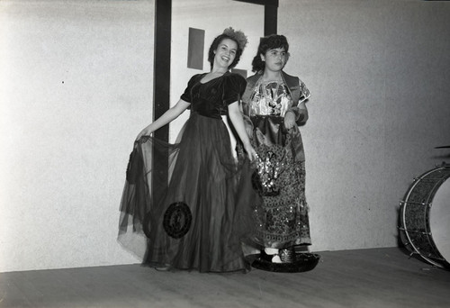 Two women dancing, one on a Mexican hat