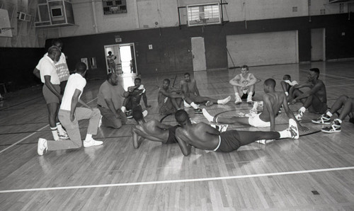 Young basketball players resting while listening to a coach, Los Angeles, ca. 1988