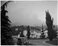 Smoke rises from a forest fire in the Glendale Woodlands, December 20, 1937