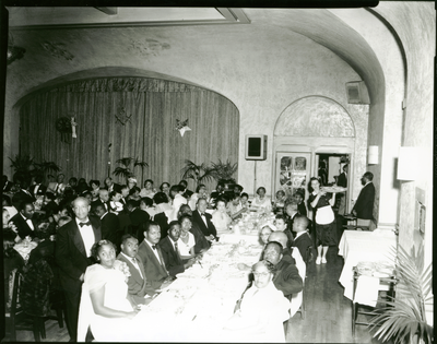 Men and women seated at dining tables in banquet hall