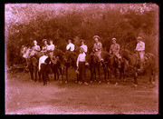 Eight people on horses; two standing