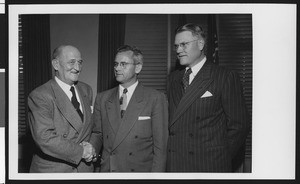 University of Southern California Athletic Director Bill Hunter shakes the hand of new head football coach Jess Hill (center) while President Fagg looks on, after they have signed Hill's football contract, USC campus, January 1951