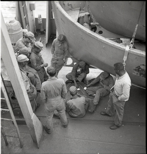 Soldiers playing cards on the deck of the USS Meigs