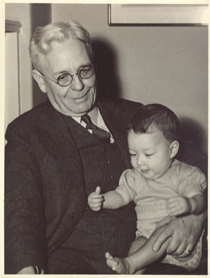 [Joseph P. Nourse, principal of Galileo High School, holding his grandchild, Joseph Nourse Goodell]