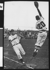 Runner touching base as a player jumps to catch the ball, ca.1940