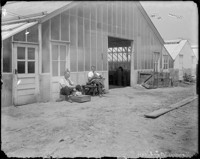 [Two men eating outside greenhouse. Johan Hagemeyer, right?] [negative]