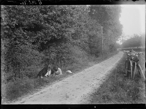 6 Vet. '10. [Couple reading in grass by roadside. 1910.] [negative]