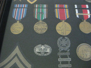 Enlarged Image of the Bottom-Left Section of the Framed Case With Acevedo's Military Honors, Awards, and Other Mementos