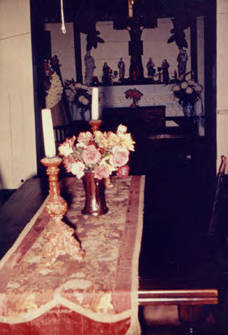Table with cloth and candles and flowers in Avila Adobe