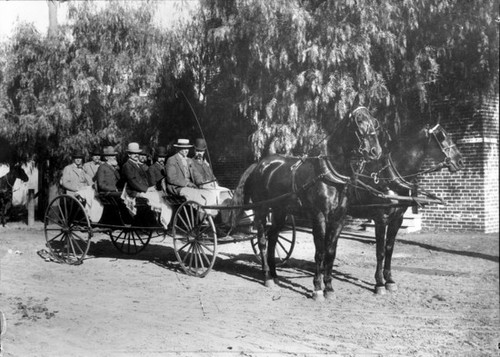 City council seated in horse-drawn carriage