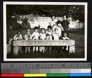 Children eating at outdoor table, China, ca.1930-1940