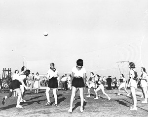 A group of women compete in a game of volleyball