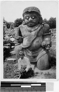 Woman sitting by a temple guard, Oceania, 1938