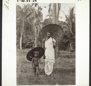 Catechist from Honor with his son and with umbrellas made from palm leaves