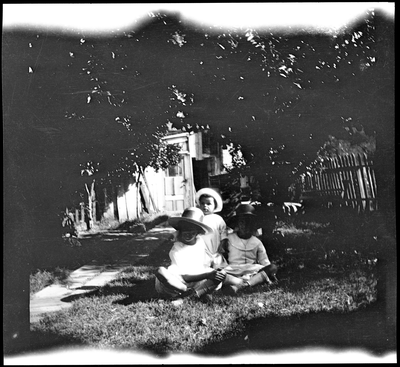 Three children sitting in backyard
