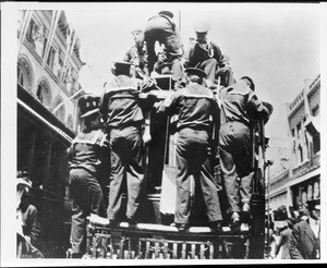 Sailors climbing the back of a streetcar in San Pedro during the visit of the Great White Fleet, 1908