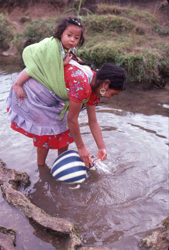 Guatemalan refugee collects water at a river, Cuauhtémoc, 1983