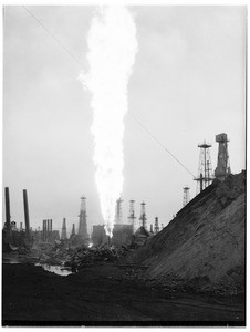 Oil geyser at an unidentified oil field, with a hill on the right