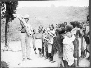 Missionary Guth showing a crucifix, Tanzania, ca. 1927-1933