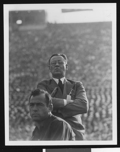 University of Southern California head football coach Jeff Cravath at the UCLA-USC game, arms crossed and lips pursed, Los Angeles Coliseum, 1944