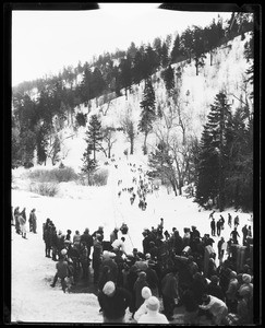 Large group of people gathered around a toboganning slope at Big Pines Camp