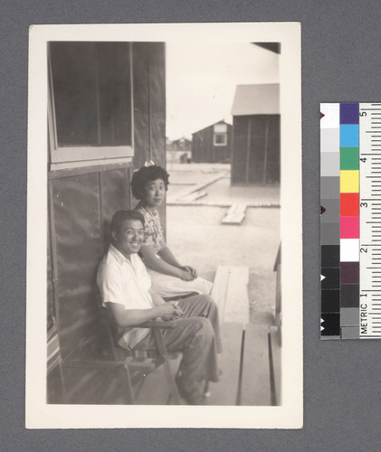 Man & woman seated on porch