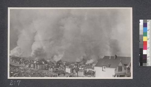 View of the fire from 22nd and Church Streets, at 2 P.M., April 19, 1906. In the foreground is shown the old Jewish burying ground and 21st and Dolores Streets on which are camped thousands of the refugees from the burnt districts. The fire did not cross 20th and Dolores Streets. At the extreme left is shown the Notre Dame convent which was burned later