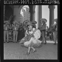 Mexican American girl in costume dancing with mariachi band at opening of Good Neighbor Week in Los Angeles, Calif., 1964