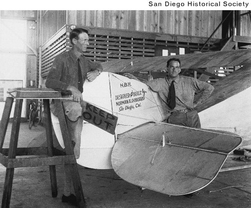 Two men leaning on the tail of the airplane El Encanto prior to the 1927 Dole Air Race to Hawaii