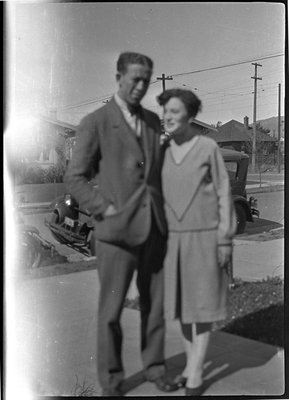 Man and woman standing on walkway in front of house