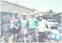 Four touring cyclists in front of garage