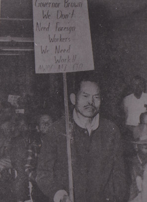 Larry Itliong holding a picket sign