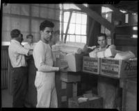 Unidentified men move boxes of food at a county food exchange program, Los Angeles, 1930s