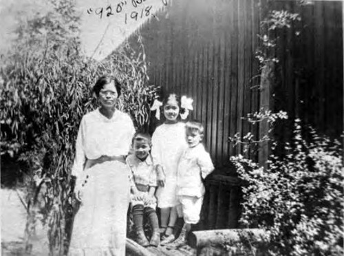 Backyard of 920, Sacramento, woman and three children