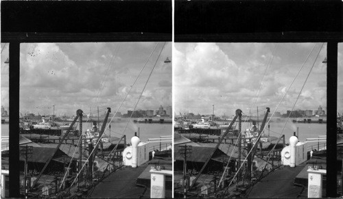 Shipping activity on south side of River, New Orleans, Portion of city in distance at right, ferry house at left