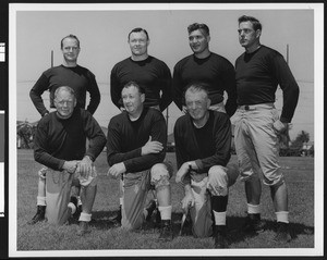 University of Southern California football coaching staff wearing dark sweatshirts, 1949, Bovard Field, USC campus