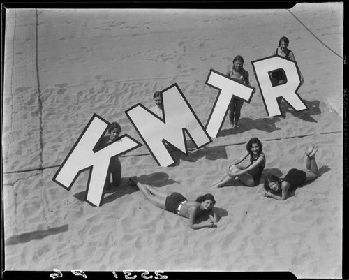 Young women on beach promoting radio station KMTR, Santa Monica, [1925-1946]