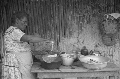 A woman works in the kitchen with grated coco, San Basilio de Palenque, 1976