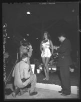 Three amateur photographers surrounding model at Los Angeles Photo Fair, 1948