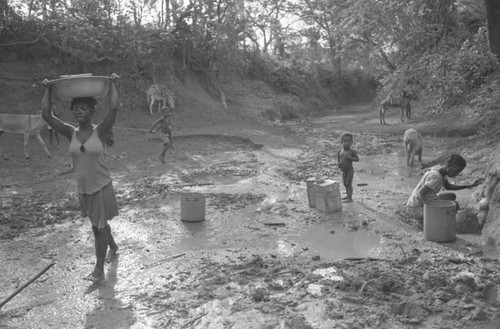A woman carrying a water receptacle on her head, San Basilio de Palenque, 1977