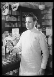 Mr. Kniger - Pharmacist at West Adams Street holding bottle, West Adams Street, Los Angeles, CA, 1934